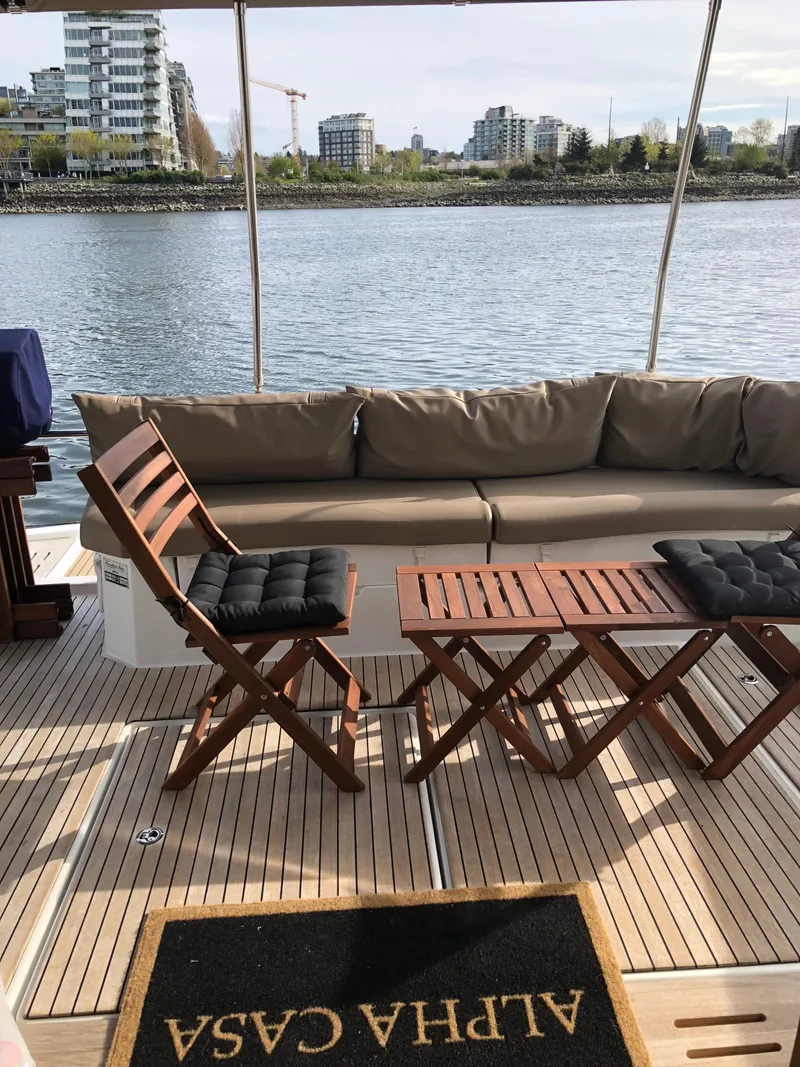 Slide: The Image of The image shows the deck of a 2016 Fountaine Pajot Motor Yacht 37 with wooden furniture. - 4