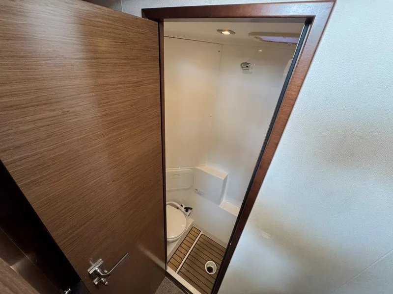 Slide: The Image of A modern bathroom with a wooden door, toilet, and shower area on a yacht. - 36
