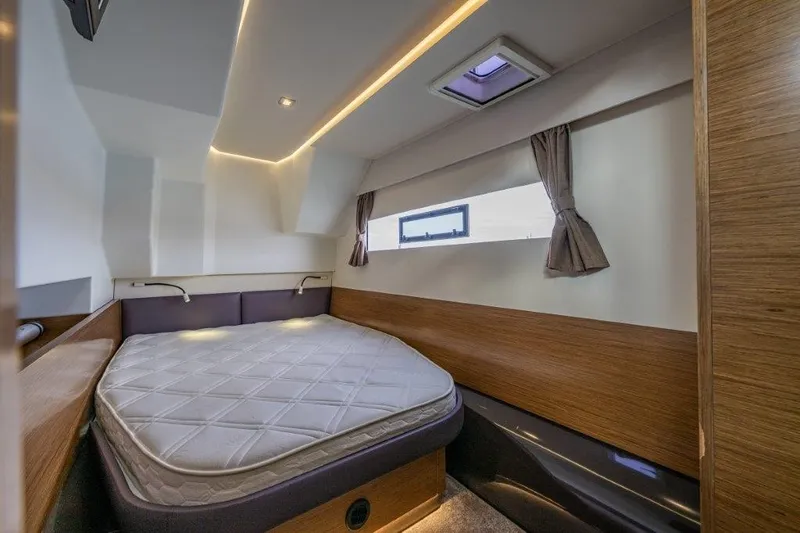 Slide: The Image of The image shows a modern cabin with a large bed, wood paneling, and a window with curtains. - 30