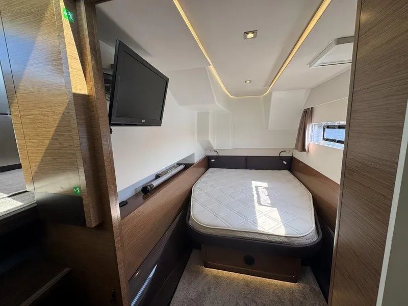 Slide: The Image of A modern cabin with a double bed, TV, and wood paneling. Windows allow natural light in. - 23