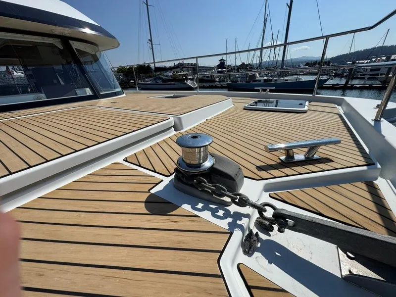 Slide: The Image of The image shows the deck of a 2016 Fountaine Pajot Motor Yacht 37 in a marina. - 41