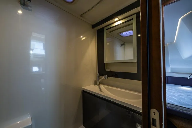 Slide: The Image of The image shows a modern yacht bathroom with a sink, mirror, and shower. - 20