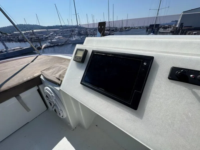 Slide: The Image of The image shows the helm of a 2016 Fountaine Pajot Motor Yacht 37 in a marina. - 46
