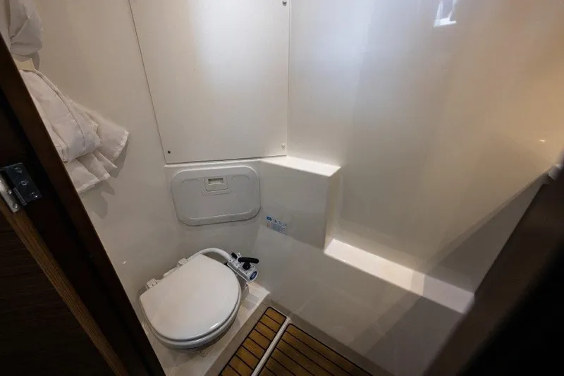 Slide: The Image of A modern yacht bathroom with a toilet and wooden flooring. - 21