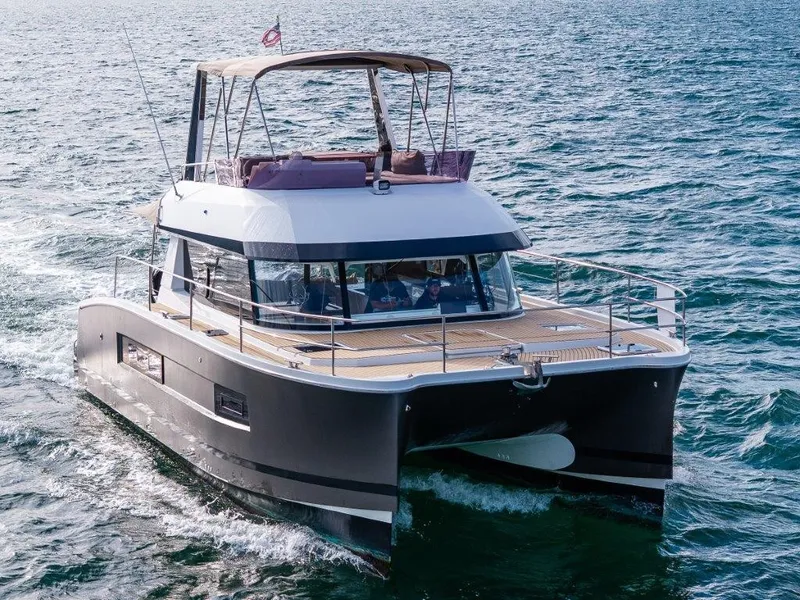 Slide: The Image of A 2016 Fountaine Pajot Motor Yacht 37 cruising on open water. It features a modern design with a spacious deck and covered helm. - 1