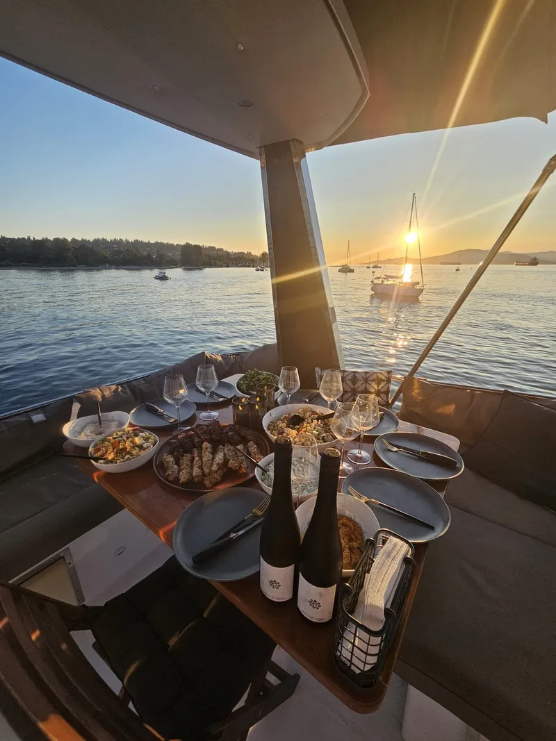 Slide: The Image of A set table on a yacht overlooking the sunset over the water. - 5