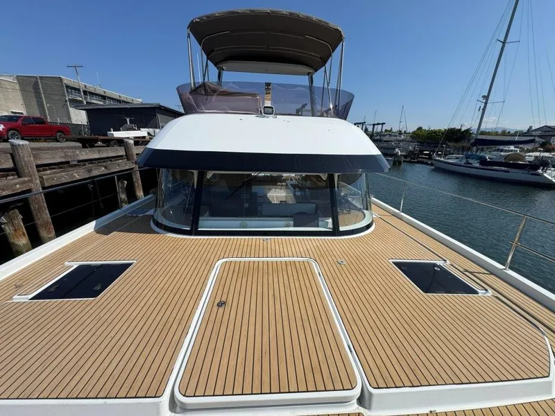Slide: The Image of The 2016 Fountaine Pajot Motor Yacht 37 is docked, featuring a spacious deck and a sunshade. - 42