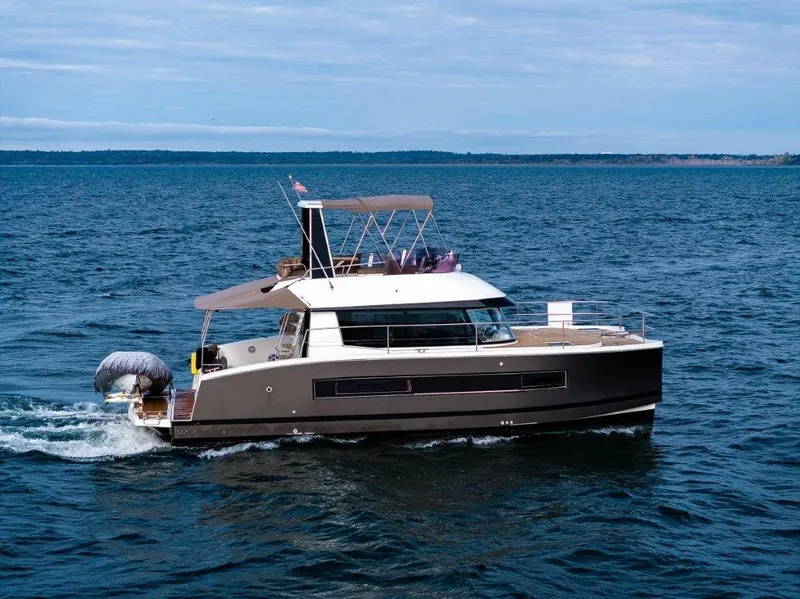 Slide: The Image of A 2016 Fountaine Pajot Motor Yacht 37 cruising on open water. It features a modern design with a spacious deck and sunshade. - 2