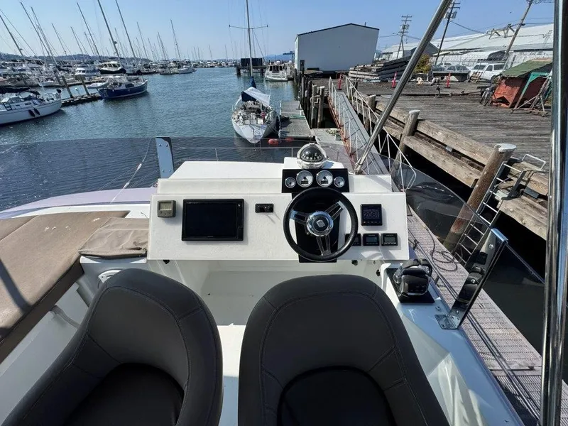 Slide: The Image of The image shows the helm of a 2016 Fountaine Pajot Motor Yacht 37 docked in a marina. - 44