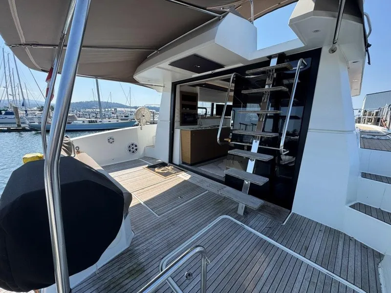 Slide: The Image of The 2016 Fountaine Pajot Motor Yacht 37 features a modern deck with wooden flooring and an open kitchen. - 2