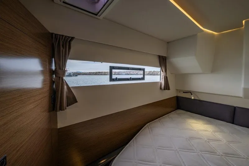 Slide: The Image of Interior of a 2016 Fountaine Pajot Motor Yacht 37 featuring a cozy bed and a window overlooking the water. - 26