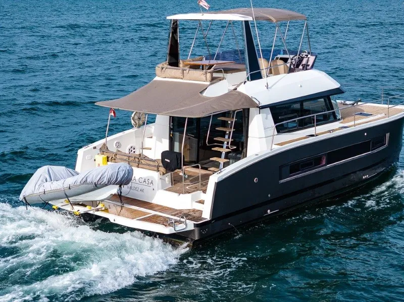 Slide: The Image of A 2016 Fountaine Pajot Motor Yacht 37 cruising on open water with a dinghy at the stern. - 3