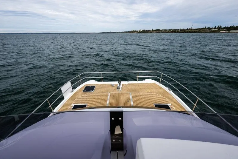 Slide: The Image of The image shows the foredeck of a 2016 Fountaine Pajot Motor Yacht 37 on the water. - 12