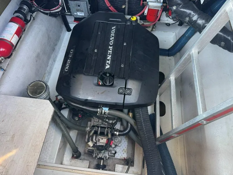 Slide: The Image of A Volvo Penta D3-220 engine in a boat's engine compartment, surrounded by hoses and a fire extinguisher. - 49