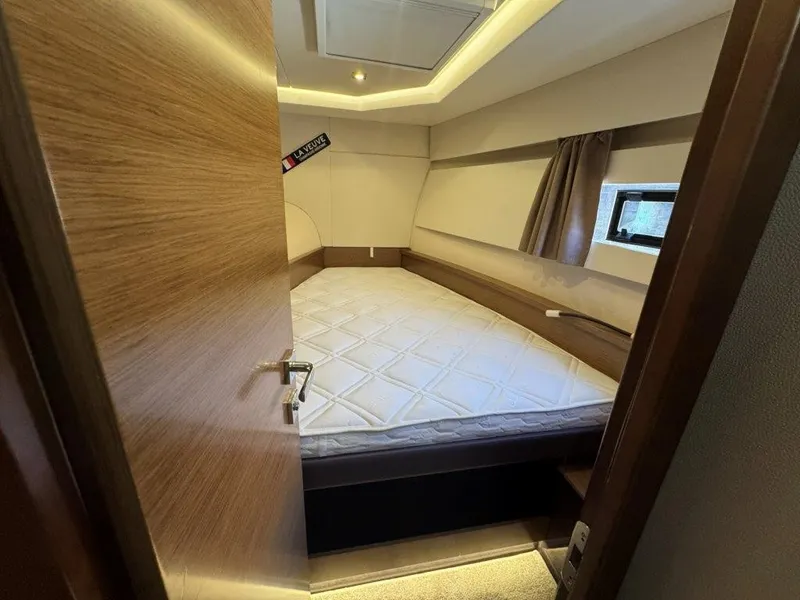 Slide: The Image of A cozy bedroom with a large bed, wooden walls, and a small window with curtains. - 34