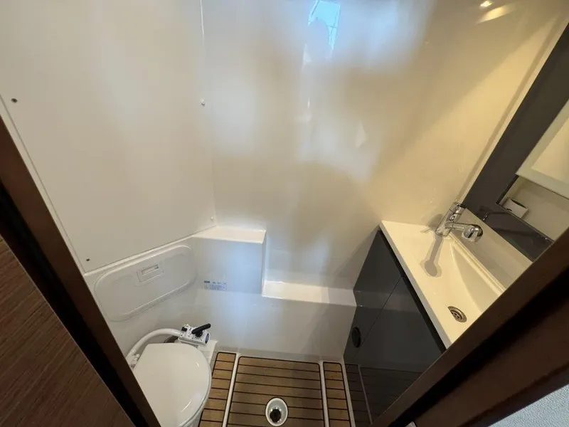Slide: The Image of The image shows a modern yacht bathroom with a toilet, sink, and wooden floor. - 37