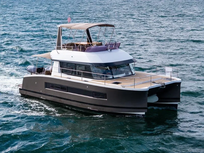 Slide: The Image of A 2016 Fountaine Pajot Motor Yacht 37 cruising on the sea. It features a modern design with a spacious deck and covered helm. - 0
