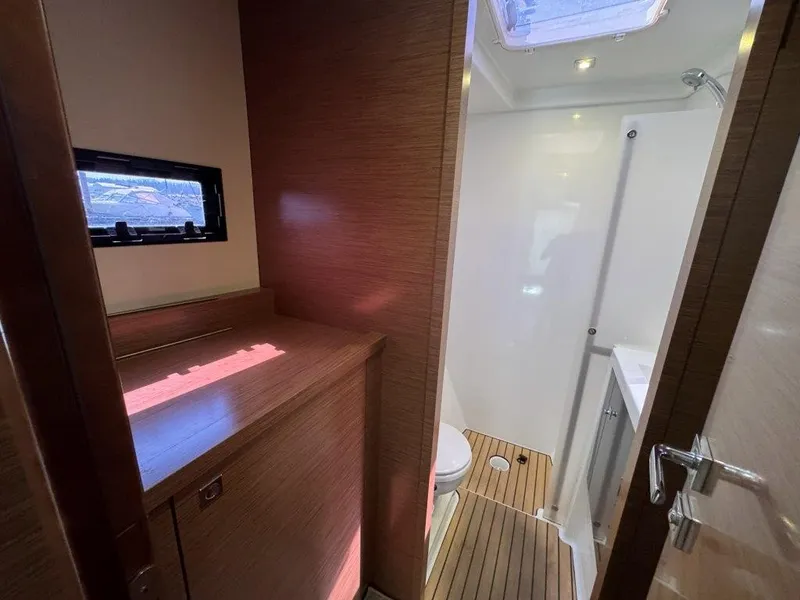 Slide: The Image of The image shows a yacht bathroom with wooden flooring and a small window. - 27