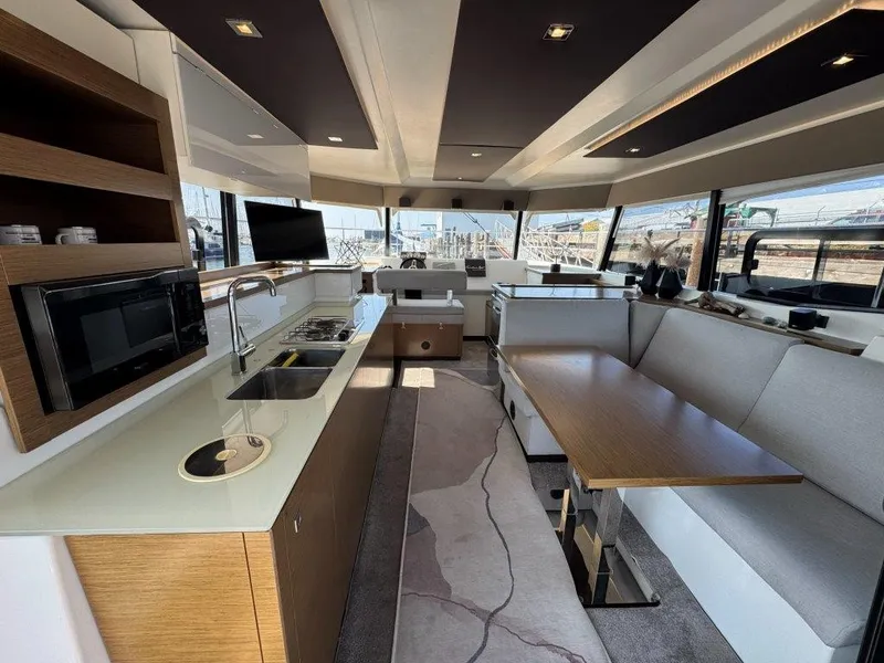 Slide: The Image of Interior of a modern yacht featuring a kitchen, dining table, and large windows. - 6