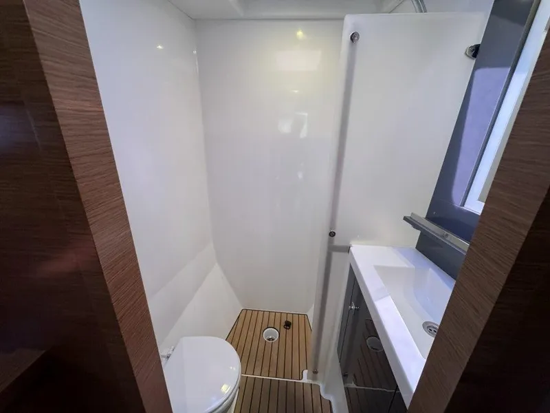 Slide: The Image of The image shows a modern yacht bathroom with a toilet, sink, and wooden flooring. - 28