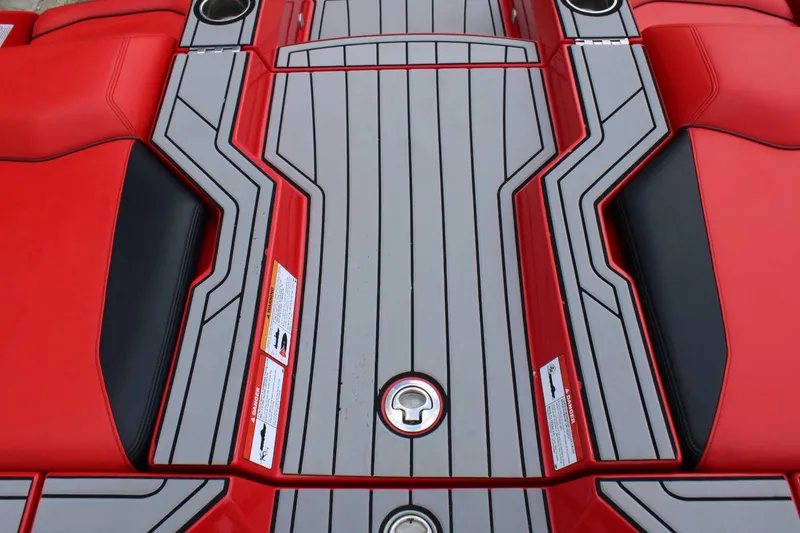 Slide: The Image of The image shows the deck of a 2021 Nautique Super Air Nautique GS22 with red and gray upholstery. - 22