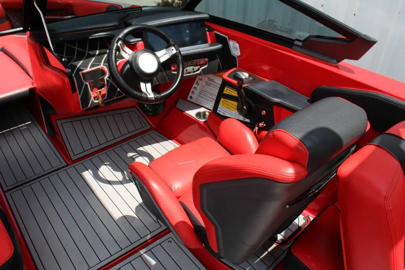 Slide: The Image of The image shows the cockpit of a 2021 Nautique Super Air Nautique GS22 with red and black seats. - 8