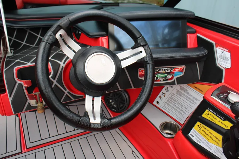 Slide: The Image of The image shows the cockpit of a 2021 Nautique Super Air Nautique GS22 with a modern steering wheel and large display. - 9