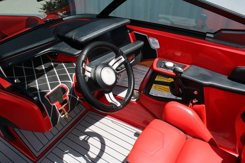 Slide: The Image of The image shows the cockpit of a 2021 Nautique Super Air Nautique GS22 with red seats and a modern dashboard. - 7