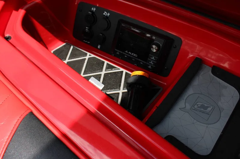 Slide: The Image of Close-up of a red boat console area with audio controls and a storage compartment. - 12