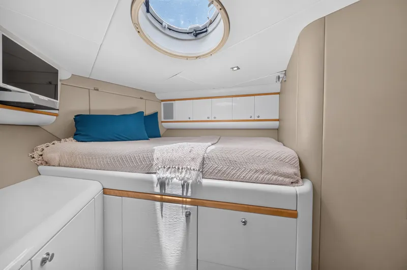 Slide: The Image of The 2001 Lazzara 80 SL cabin features a cozy bed, cabinets, and a porthole. - 49