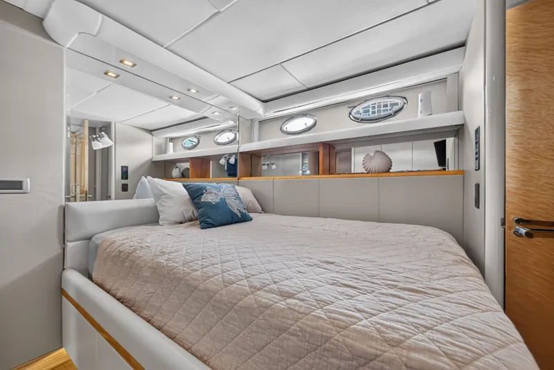 Slide: The Image of Luxurious cabin with a large bed, decorative pillows, and porthole windows on the sides. - 32