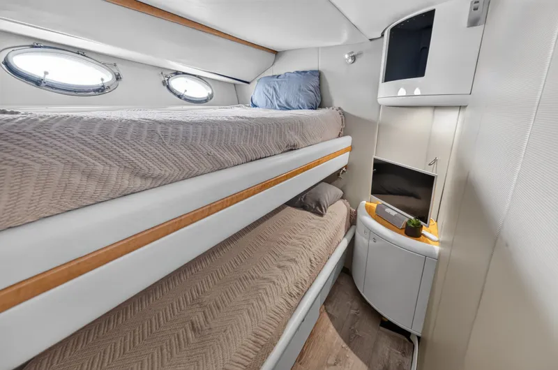 Slide: The Image of The 2001 Lazzara 80 SL cabin features bunk beds, portholes, and a small TV. - 45