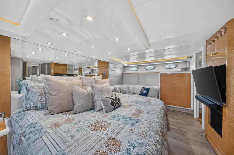 Slide: The Image of Luxurious cabin with a large bed, decorative pillows, and a flat-screen TV on the wall. - 27