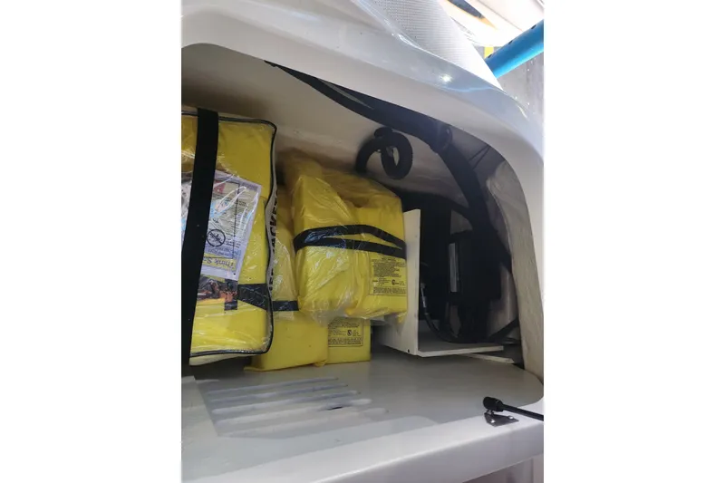 Slide: The Image of Storage compartment of 2022 Sea Ray SPX 210 Outboard with yellow life jackets. - 16
