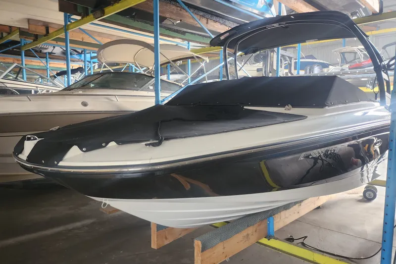 The Image of 2022 Sea Ray SPX 210 Outboard boat in storage, covered and elevated on racks. - 0