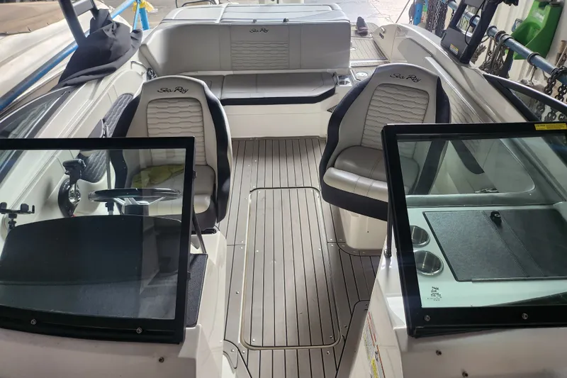 Slide: The Image of 2022 Sea Ray SPX 210 Outboard boat interior with seating and steering wheel. - 11