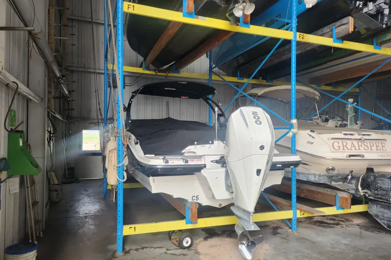 Slide: The Image of 2022 Sea Ray SPX 210 Outboard boat stored in a warehouse rack. - 1