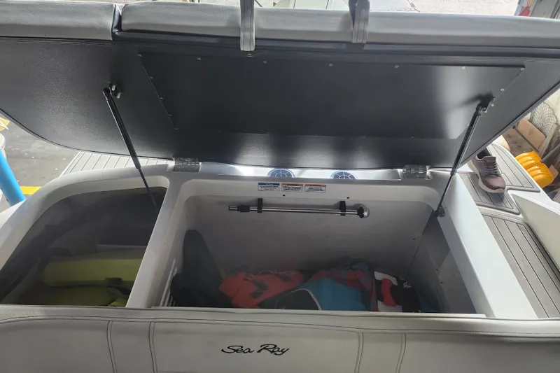 Slide: The Image of Open storage compartment of 2022 Sea Ray SPX 210 Outboard boat with life jackets inside. - 19