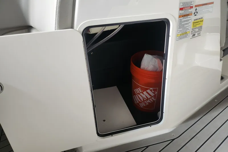 Slide: The Image of Storage compartment on a 2022 Sea Ray SPX 210 Outboard with a Home Depot bucket inside. - 17