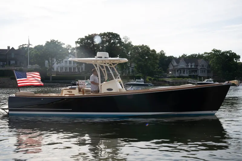 Slide: The Image of 2014 Hinckley Talaria 29C boat on calm water with American flag. - 7