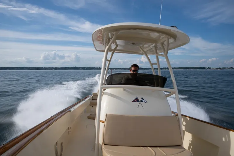 Slide: The Image of 2014 Hinckley Talaria 29C cruising on open water under a clear blue sky. - 28