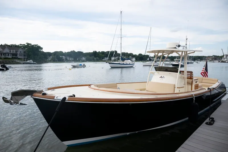Slide: The Image of 2014 Hinckley Talaria 29C boat docked in a scenic marina setting. - 9