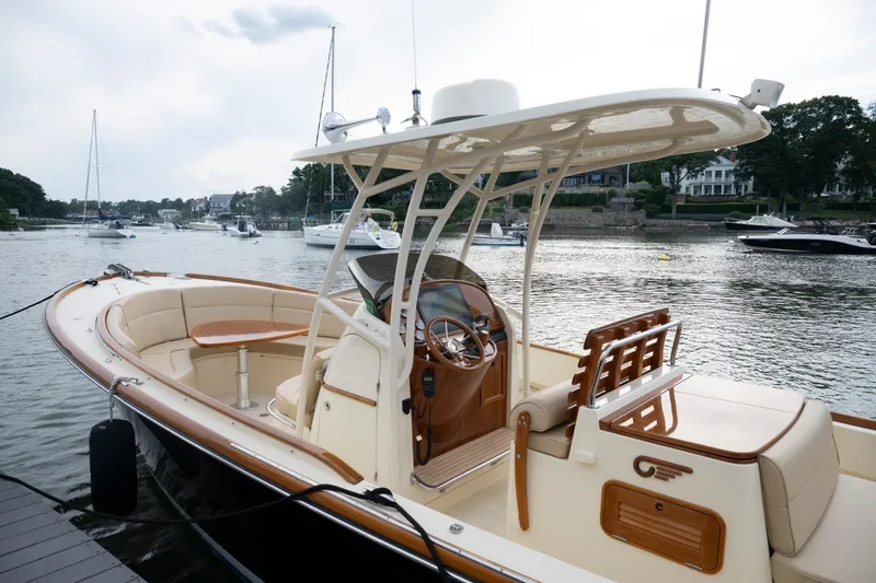 Slide: The Image of 2014 Hinckley Talaria 29C boat docked on a serene waterfront. - 2