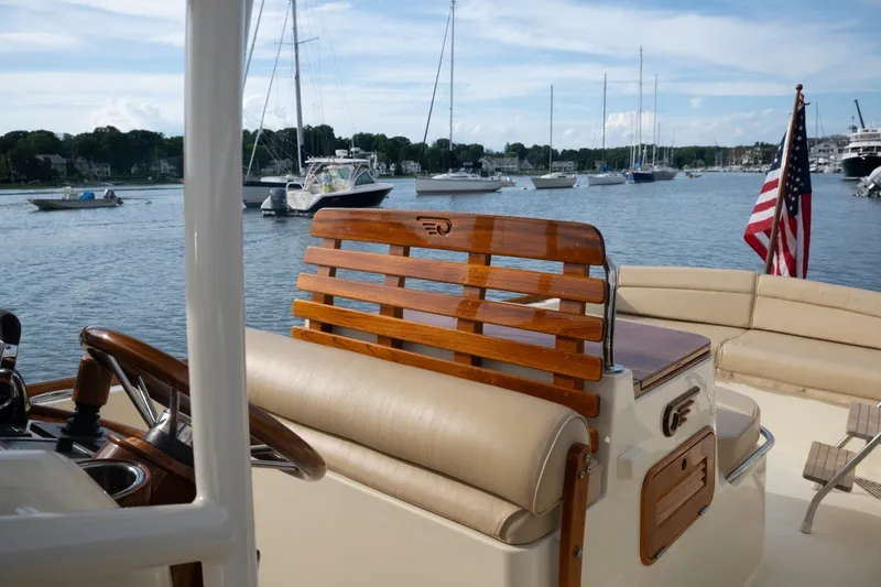 Slide: The Image of 2014 Hinckley Talaria 29C yacht interior with wooden accents, docked in a scenic marina. - 20