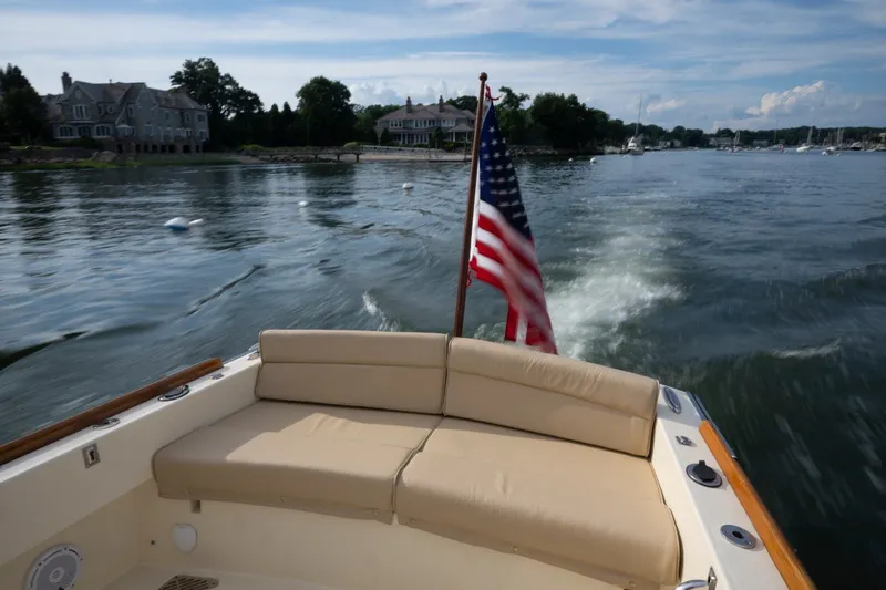 Slide: The Image of 2014 Hinckley Talaria 29C cruising on a scenic waterway with American flag. - 27
