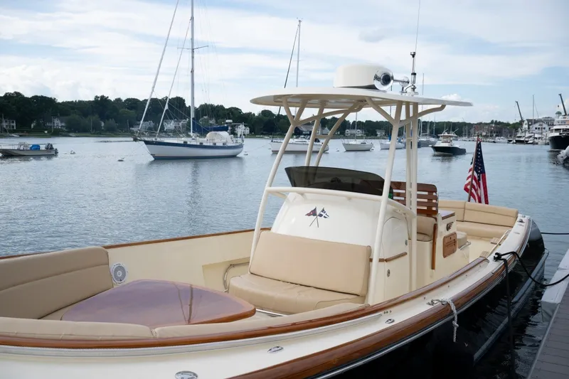 Slide: The Image of 2014 Hinckley Talaria 29C boat docked in a scenic marina with sailboats. - 13