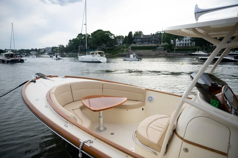 Slide: The Image of 2014 Hinckley Talaria 29C boat with elegant seating, docked in a scenic harbor. - 3