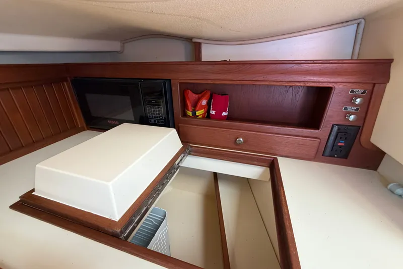 Slide: The Image of Interior of 2000 Island Packet 320 sailboat with microwave and storage compartments. - 59