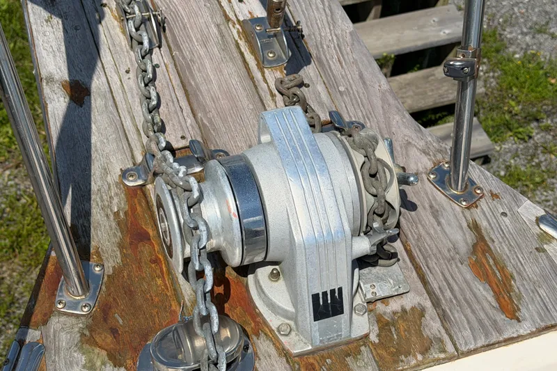 Slide: The Image of Anchor windlass on 2000 Island Packet 320 sailboat deck, with chain and weathered wood. - 20