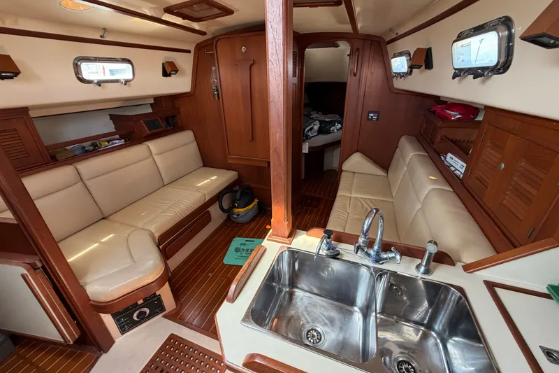 Slide: The Image of Interior of 2000 Island Packet 320 sailboat with beige seating and wooden finishes. - 52